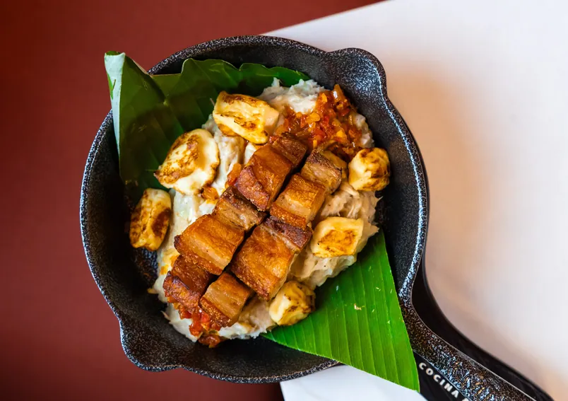 Chicharrón with patacones on a plantain leaf