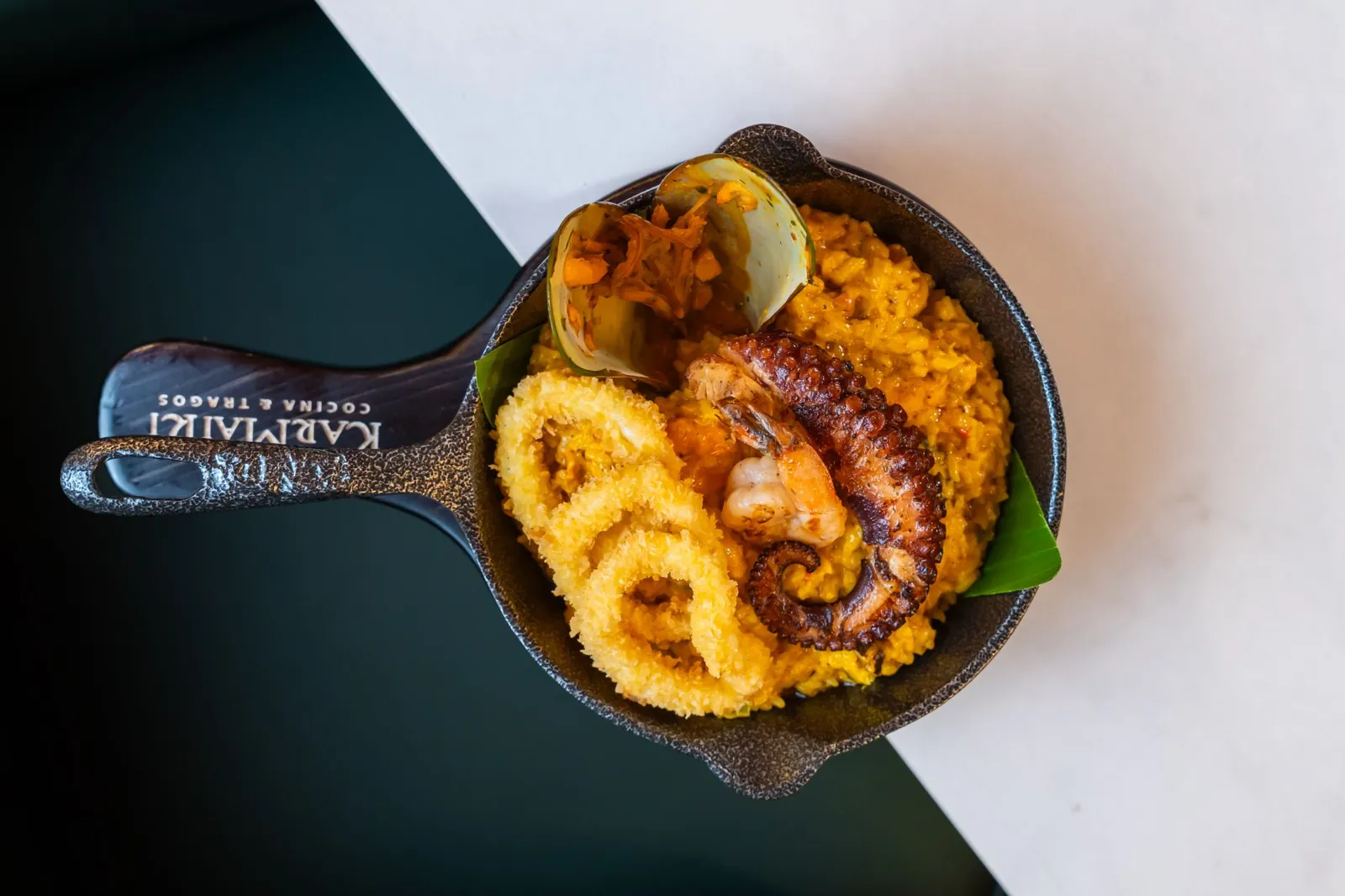 Arroz cremoso de mariscos con calamares y pulpo en sartén de hierro