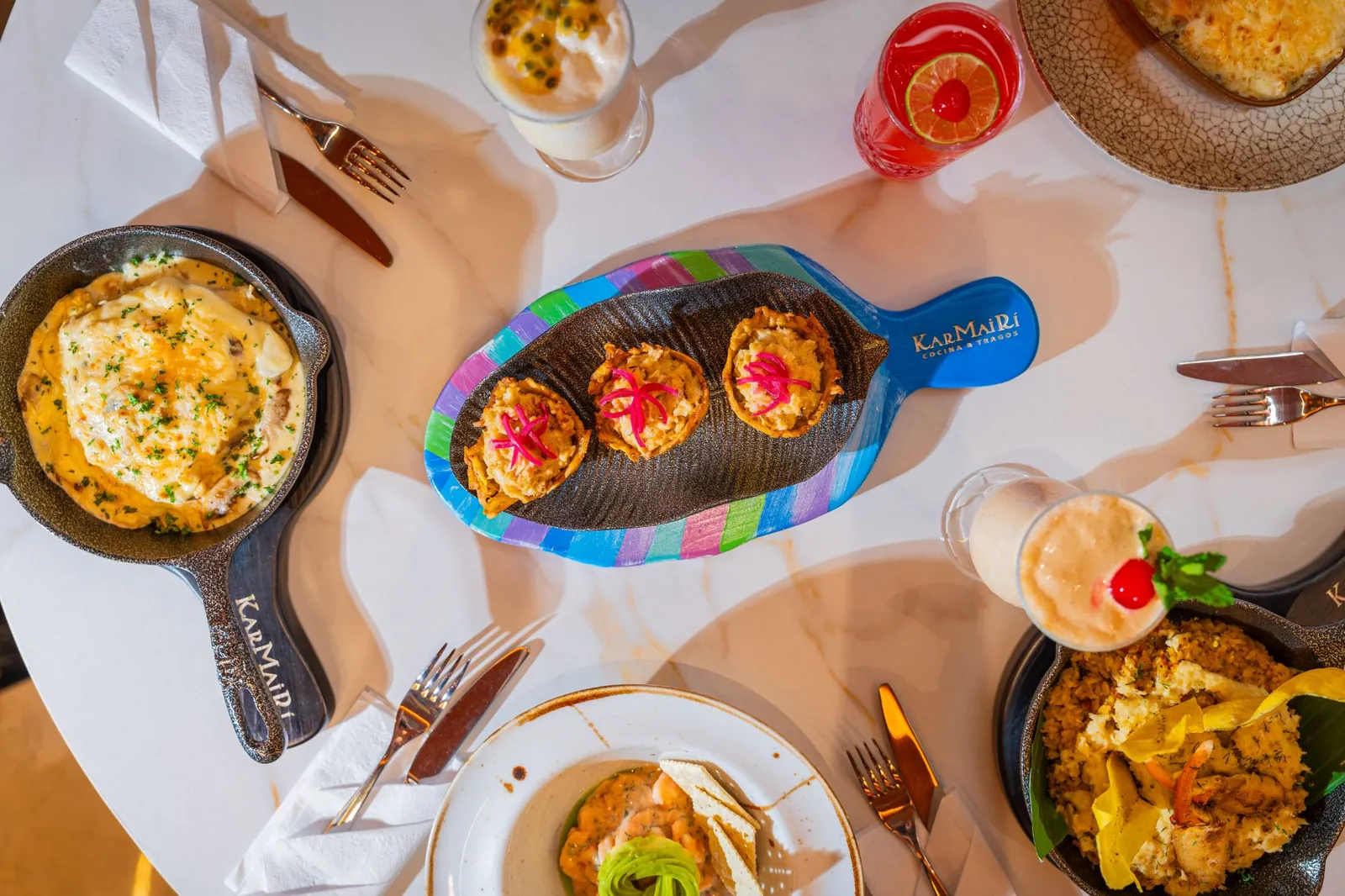 Mesa servida con platos del Caribe y cócteles