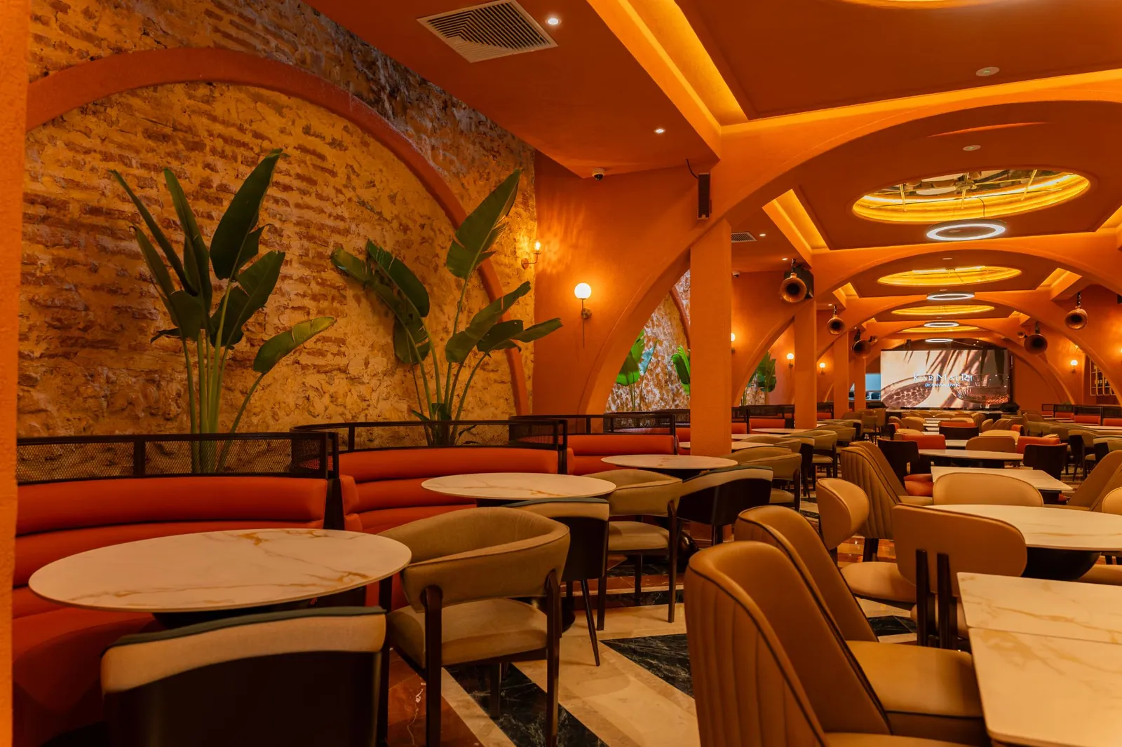 Dining room with terracotta banquettes and a brick wall